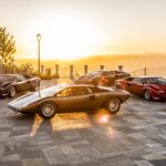 Vier verschiedene Modelle des Lamborghini Countach, aufgereiht nach ihrer zeitlichen Entwicklung, glänzend unter dem Sonnenlicht.