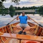 Das Foto zeigt einen Badesee und einen Mann in einem Paddelboot