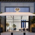 Das Foto zeigt die Außenansicht der weltweit ersten Bugatti Home Boutique in Dubai, mit eleganter Glasfassade, modernem Design und einem markanten Bugatti-Logo.